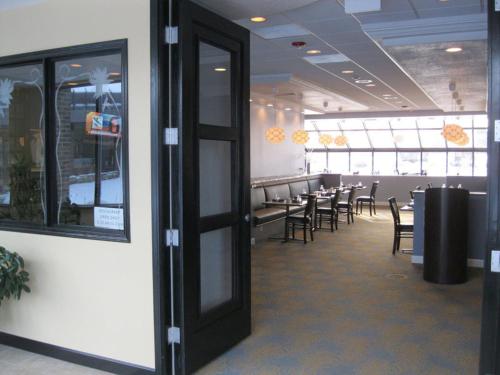 a dining room with tables and chairs in a restaurant at Causeway Bay Hotel in Lansing