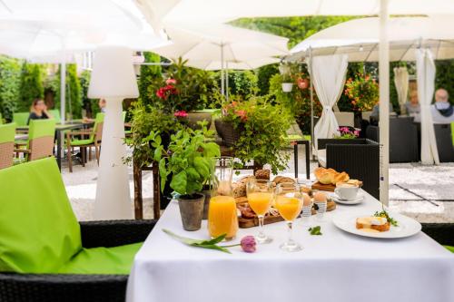 Una mesa con un plato de comida y vasos de jugo de naranja. en Art & Garden Residence, en Cracovia