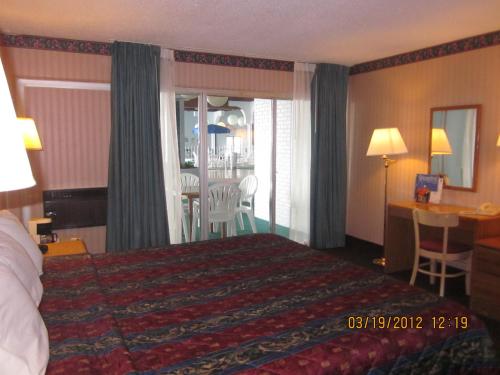 a hotel room with a bed and a table and chairs at Howard Johnson by Wyndham Saint Joseph Benton Harbor in Benton Harbor