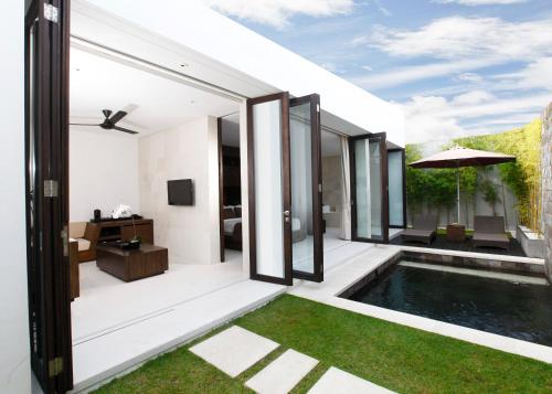 an external view of a house with a swimming pool at eqUILIBRIA Seminyak in Seminyak