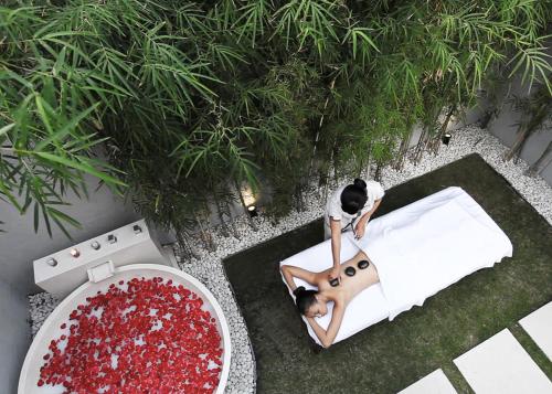 a man is sitting on a bed in at eqUILIBRIA Seminyak in Seminyak