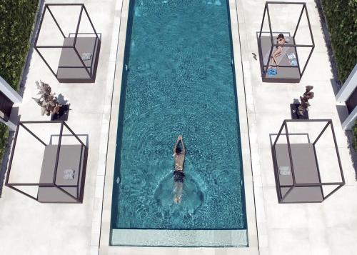 an overhead view of a person in a pool of water at eqUILIBRIA Seminyak - CHSE Certified in Seminyak