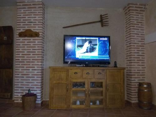 TV de pantalla plana en la parte superior de un armario de madera en Casa Rural Isabel en Villaflores