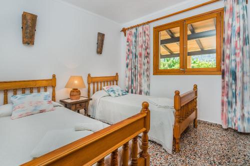 ein Schlafzimmer mit zwei Betten und einem Fenster in der Unterkunft Can Boi in Pollença