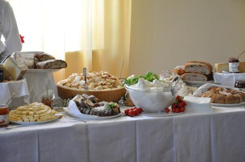 a table topped with different types of bread and pastries at Impero Hotel Beauty & Spa - Bike Hotel in Cantello