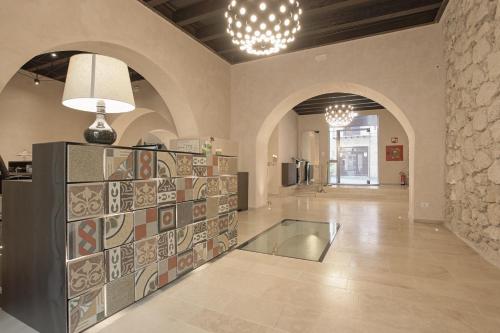 a lobby with a glass floor and two chandeliers at Alba Palace Hotel in Favara