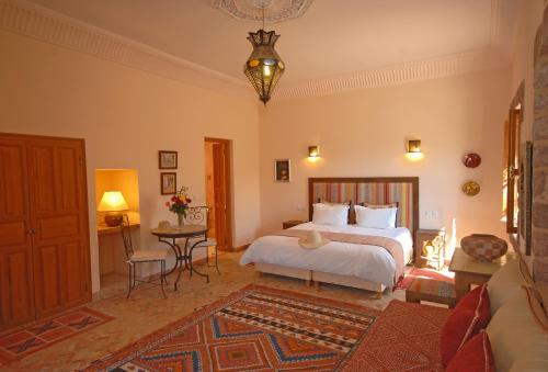 a bedroom with a bed and a table at Kasbah Angour in Tahannout