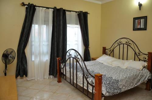 - une chambre avec un lit en face d'une fenêtre dans l'établissement Namugongo Holiday Home, à Kasiyirize