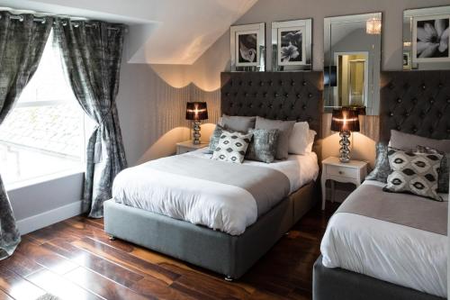 a bedroom with two beds and a window at The Tailor's House Guest Rooms in Dunmoyle