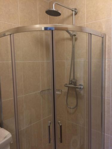 La salle de bains est pourvue d'une douche avec une porte en verre. dans l'établissement Cornerstone 2 Bed Townhouse, à Charlestown