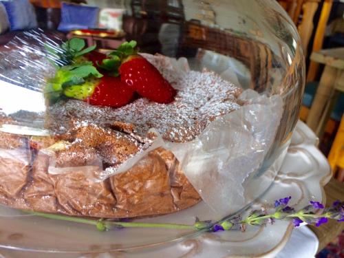 a dessert with strawberries and powdered sugar in a glass bowl at Le Mahi Guest House in Langebaan