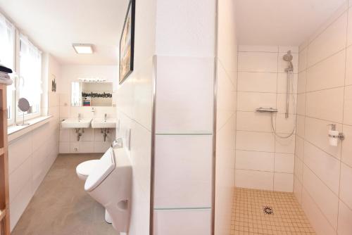 ein weißes Bad mit einem WC und einem Waschbecken in der Unterkunft Ferienhaus Stark in Eisenach