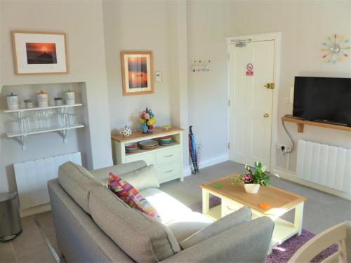 - un salon avec un canapé et une télévision dans l'établissement Chalice Lodge, à Glastonbury