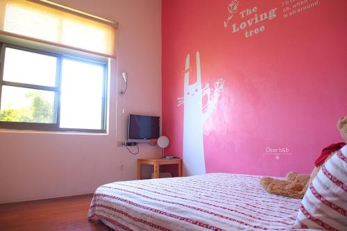 a bedroom with a bed and a pink wall at Ecotourism skim month B & B in Xiaoliuqiu