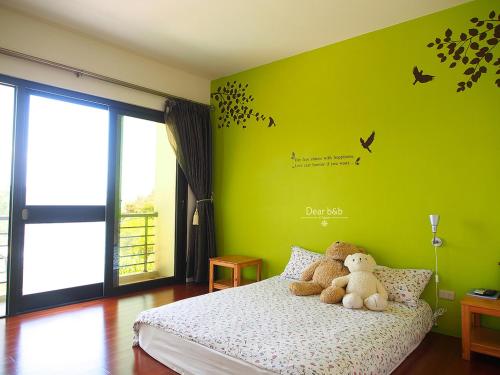 a bedroom with a bed with two teddy bears on it at Ecotourism skim month B & B in Xiaoliuqiu