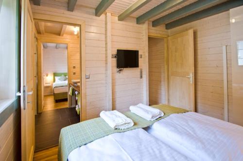 - une chambre avec un lit et des serviettes dans l'établissement Ferienblockhaus Auerhahn & Luchs, à Hahnenklee