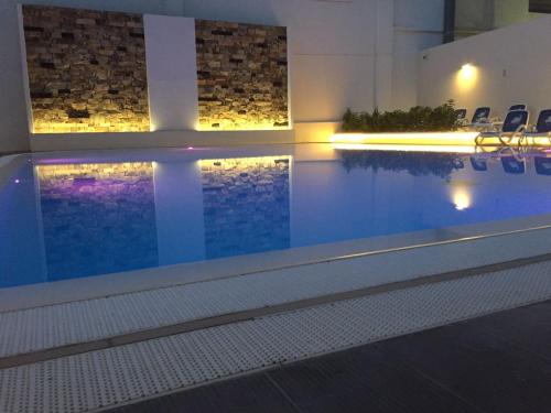 a swimming pool in a building with chairs around it at Hotel Miramare in Marina di Ragusa