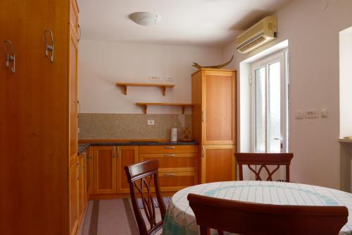 a kitchen with a table and chairs in a room at Apartments and Rooms Oražem Zoro in Portorož