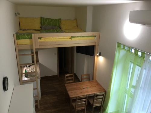 a small room with a bunk bed and a table at Penzion U Hujňáků in Rohatec