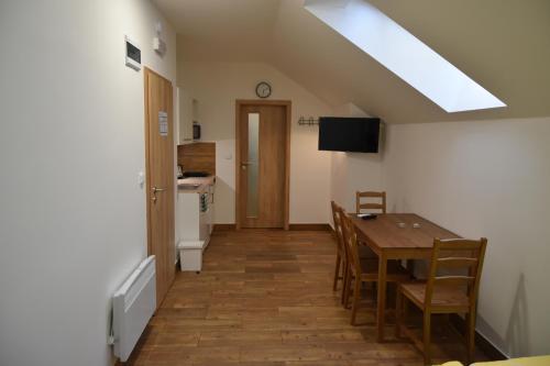 a kitchen and dining room with a table and chairs at Penzion U Hujňáků in Rohatec