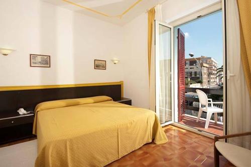 a bedroom with a bed and a large window at Hotel La Playa in Alghero