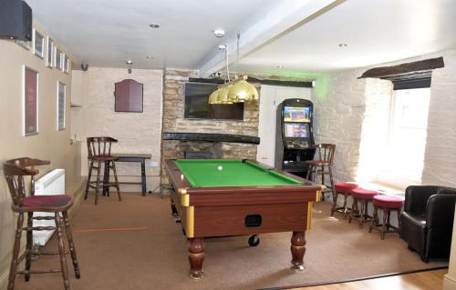 a room with a pool table in a room with chairs at The Red Lion in Cardigan