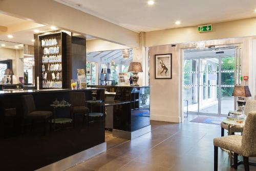 a bar in a restaurant with chairs and tables at Hotel Acadie Les Ulis in Les Ulis