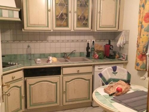 a kitchen with green cabinets and a sink and a table at Gîte "Smart'In" in Eguisheim