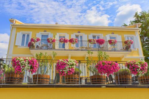 um edifício amarelo com flores numa varanda em Frajona Apartments em Malinska