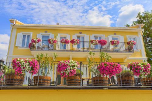 a yellow building with flowers on a balcony at Frajona Apartments in Malinska