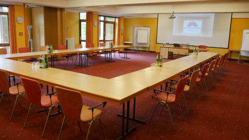 a large room with tables and chairs in a classroom at Hessen Hotelpark Hohenroda in Hohenroda
