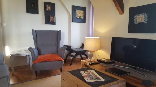 un salon avec une télévision et deux chaises et une table dans l'établissement L'Horizon Holiday Apartment, à Erquy