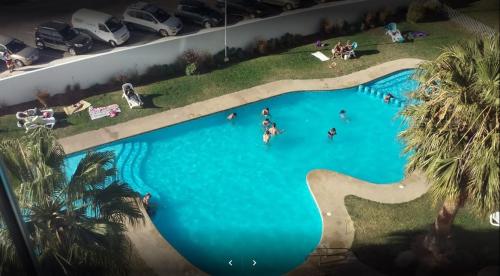 an overhead view of a swimming pool with people in it at Departamento Costa Mansa in Coquimbo