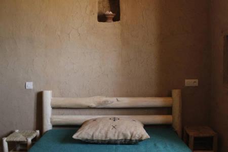 a bed with a pillow on it in a room at Kasbah Izoran in Midelt