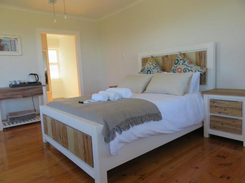 a bedroom with a large white bed with towels on it at The Noble Ant in George