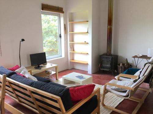 a living room with a couch and chairs and a television at Quinta da Falésia - Casa Amarela in Ponta Delgada