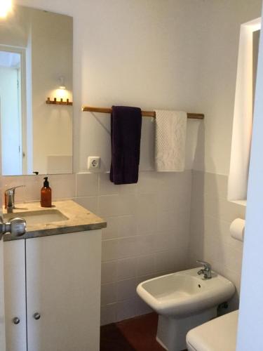 a bathroom with a sink and a toilet and a mirror at Quinta da Falésia - Casa Amarela in Ponta Delgada