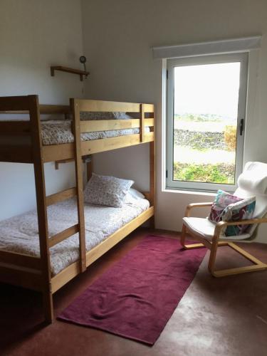 a bedroom with two bunk beds and a window at Quinta da Falésia - Casa Amarela in Ponta Delgada