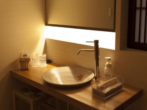 a bathroom counter with a sink and a mirror at Gokuraku Onsen Takumi no Yado in Takaharu