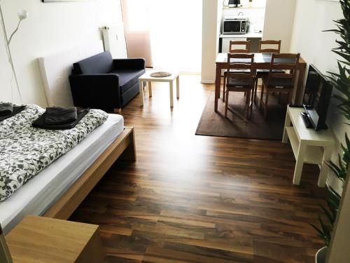 a living room with a bed and a dining room at Apartment Treetown in Regensburg