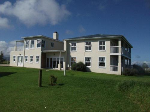 a large white house on a grass field at The Noble Ant in George