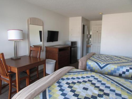 a hotel room with two beds and a desk and a mirror at Douglas Inn & Suites, Blue Ridge, GA in Blue Ridge