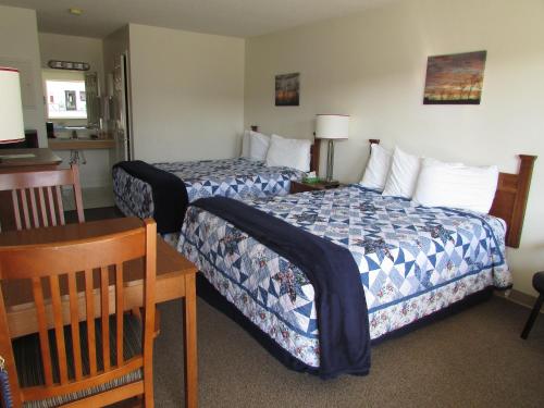 Douglas Inn & Suites, Blue Ridge, GA في بلو ريدج: غرفة فندقية بسريرين وطاولة