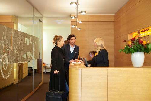 a group of people standing at a reception desk at Hotel VICTORIA Nürnberg in Nürnberg