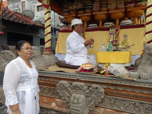 a man and a woman standing in front of a temple at Nick's Homestay in Ubud