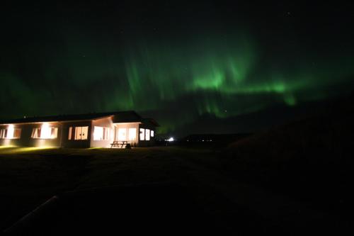 a house with the aurora in the sky at Lambastadir Guesthouse in Selfoss