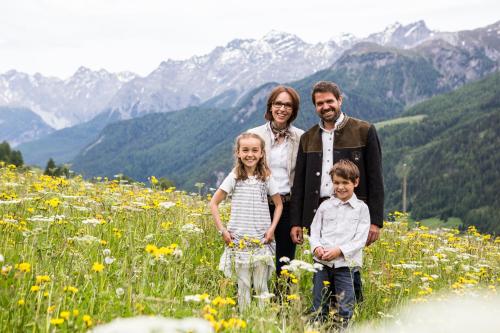 a family standing in a field of flowers at Meisser Hotel "superior" in Guarda