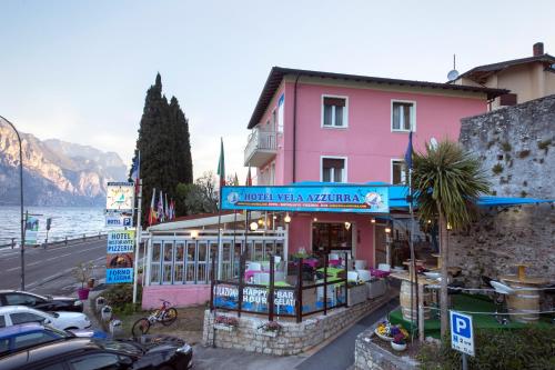 a pink building on the side of a street at Hotel Vela Azzurra in Malcesine