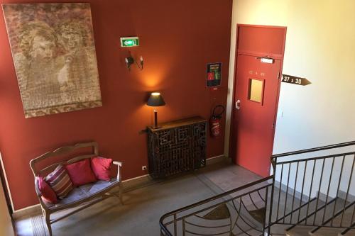 a living room with a red wall and a door at Hotel Le Magnan in Avignon