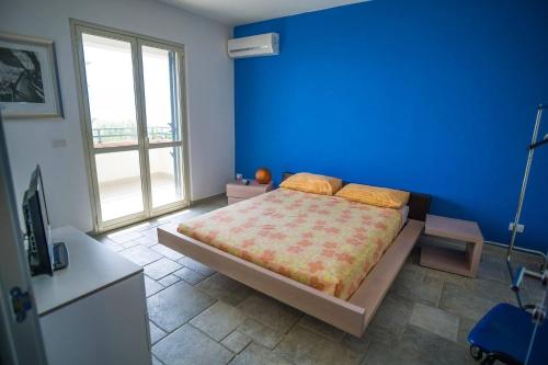 ein Schlafzimmer mit einer blauen Wand und einem Bett in der Unterkunft B&B dormirereggiocalabria in Reggio di Calabria